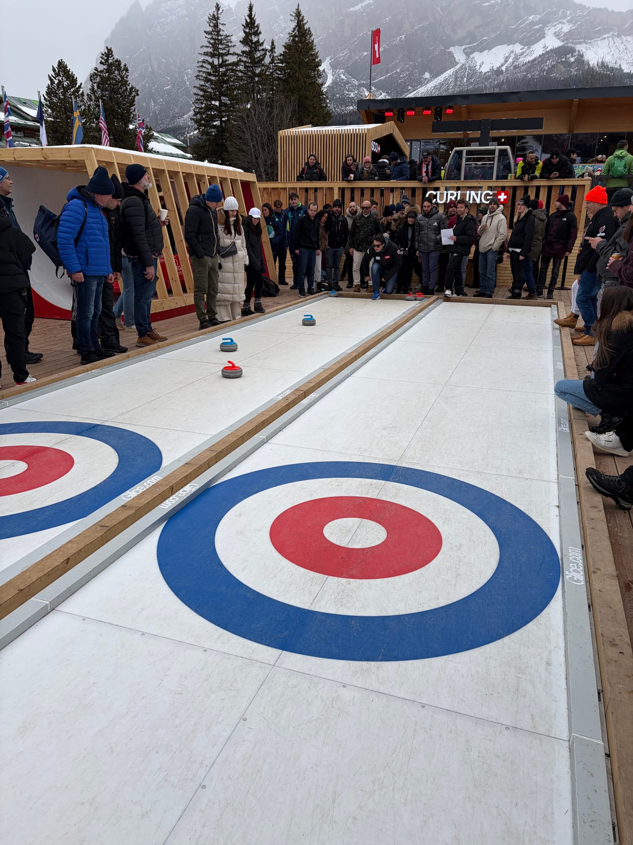 Visitors playing on the two Glice curling lanes at the House of Switzerland in Cortina