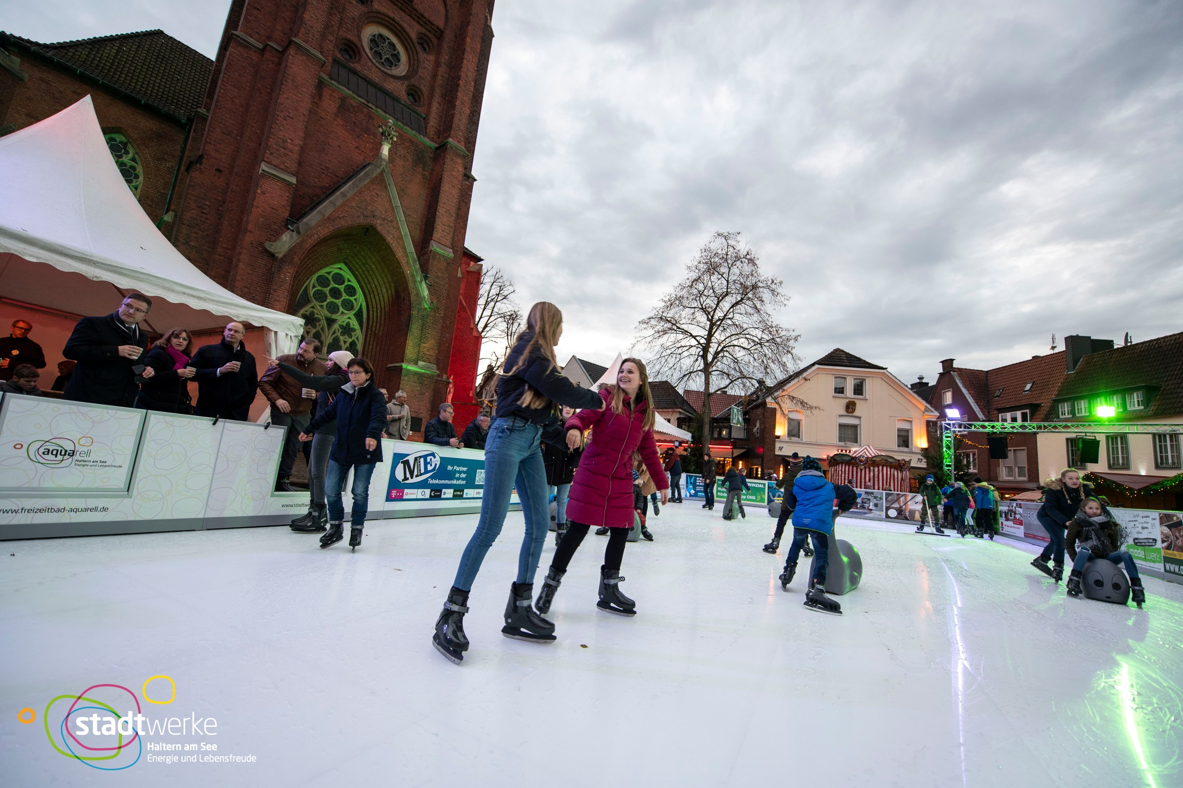 Goście jeżdżący na łyżwach na Nikolausmarkt przed kościołem Sixtuskirche w Haltern am See