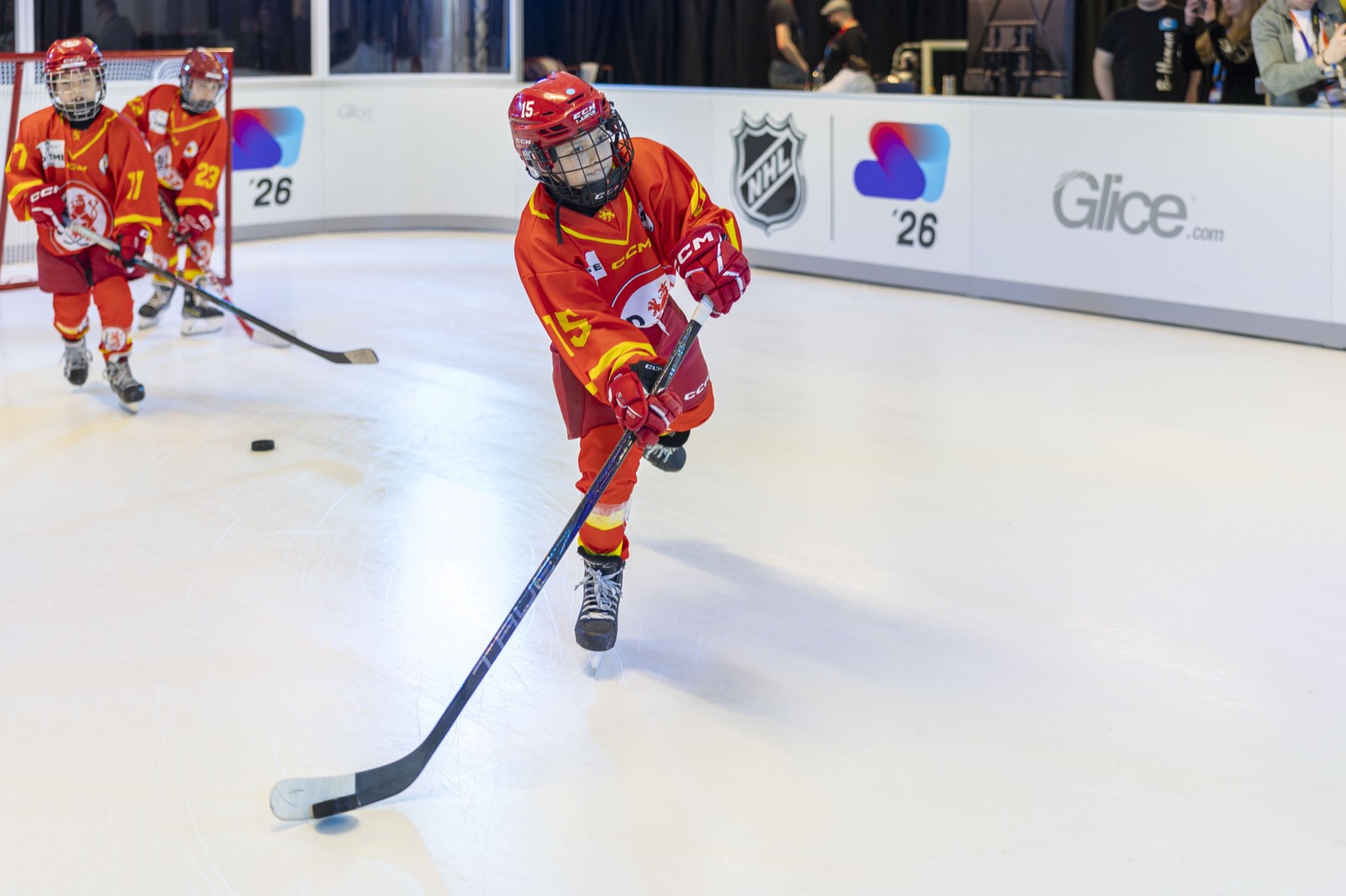 En ung Düsseldorfer EG-spiller skøyter med pucken på Glice-banen