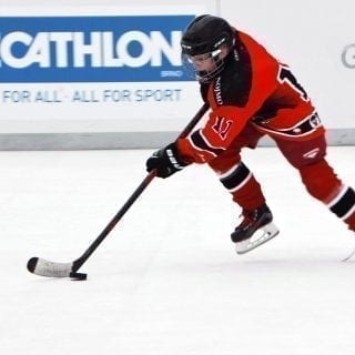 Ice Hockey Player Gliding On Artificial Ice Rink