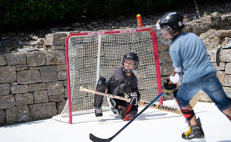 two kids playing ice rink on backyard ice rink