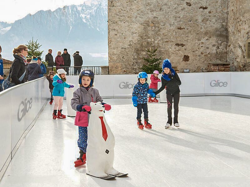 Kids with skating aid on synthetic ice