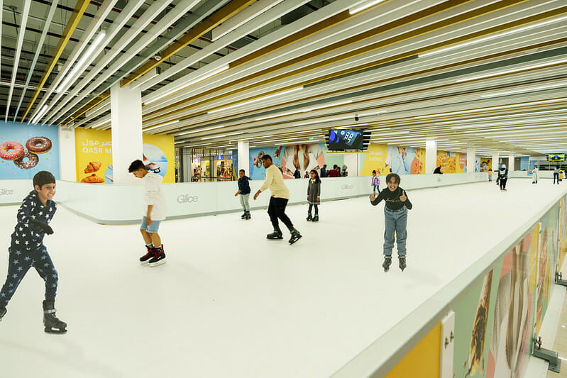 Kids skating on ice rink inside shopping mall