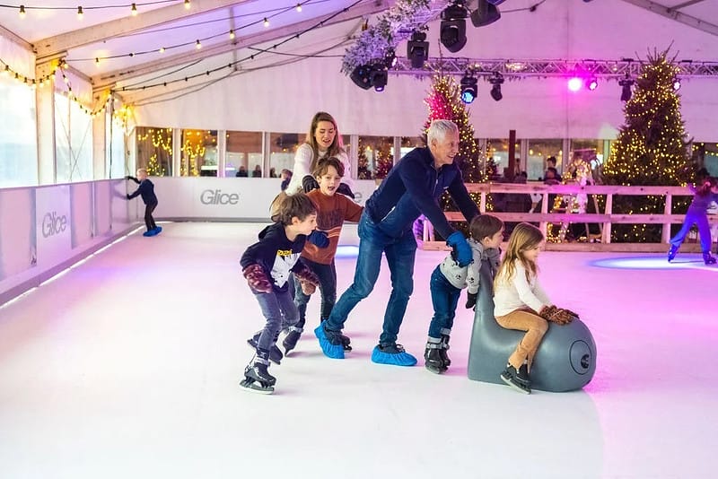 family ice skating together on synthetic ice