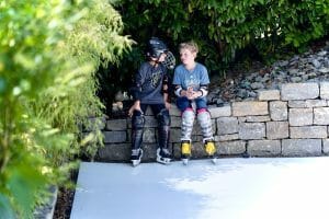 Two boys taking a break from skating on their Glice home rink