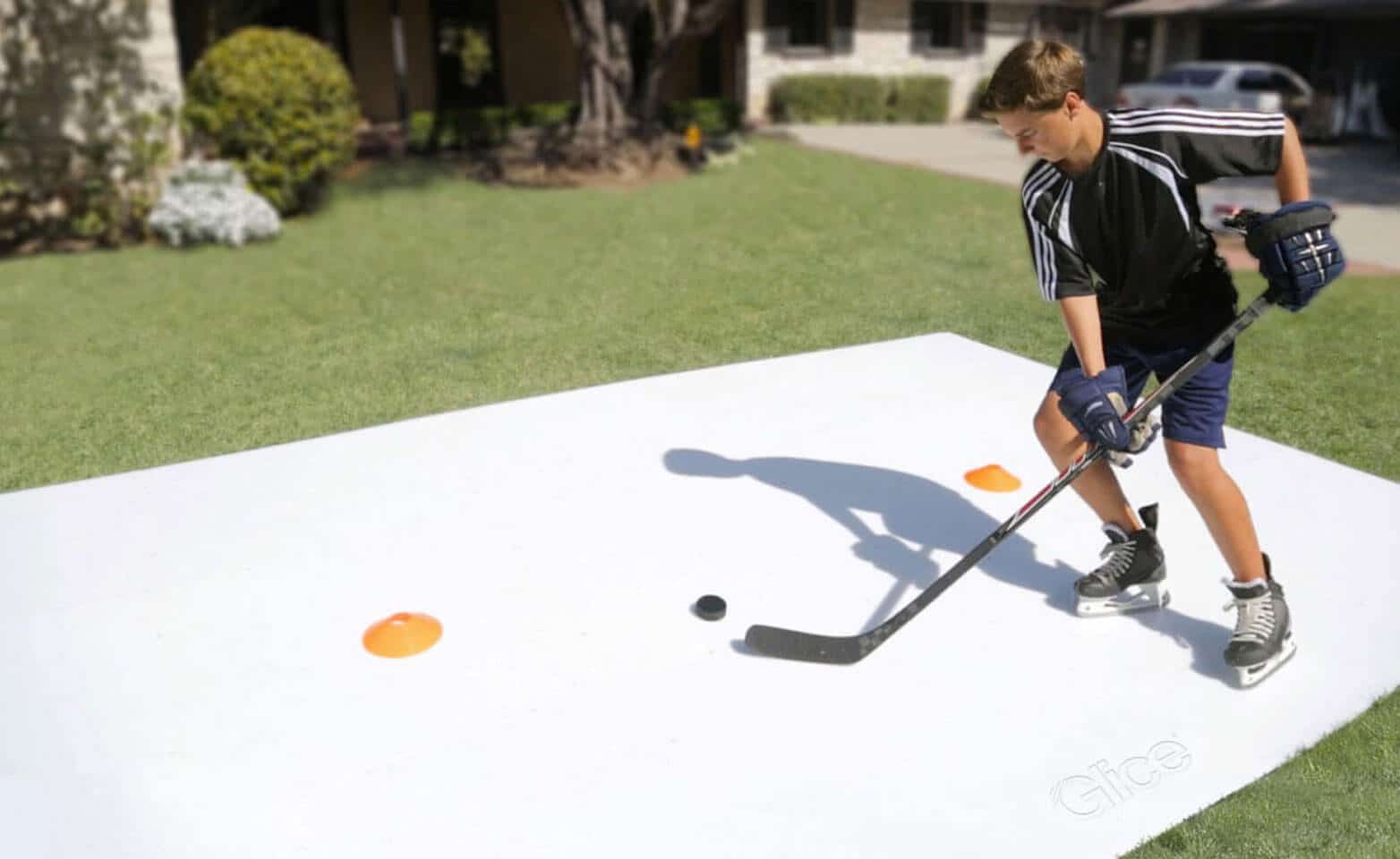 Jongen oefent ijshockey op kunstijs