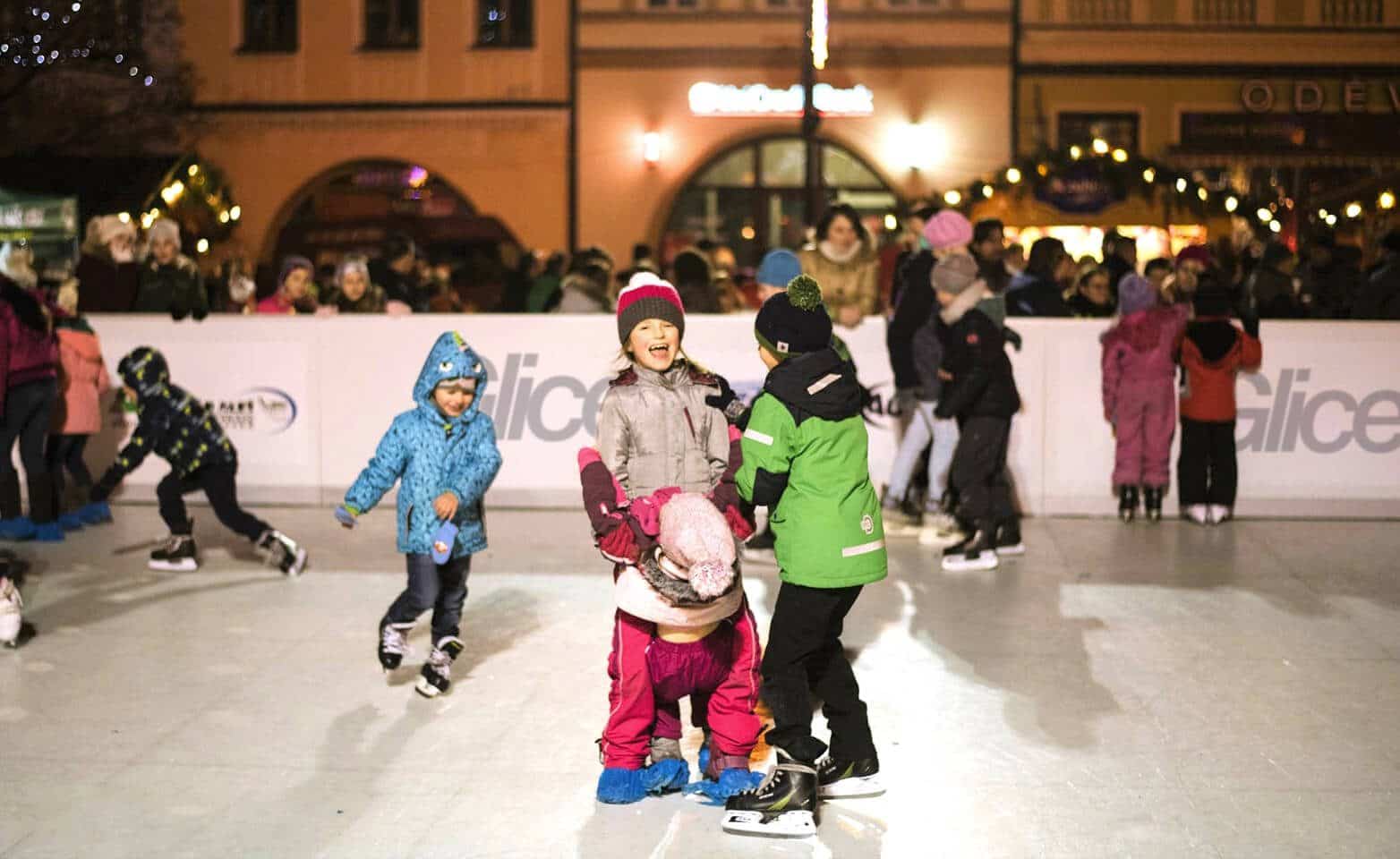 Děti bruslící o Vánocích na umělém kluzišti Glice