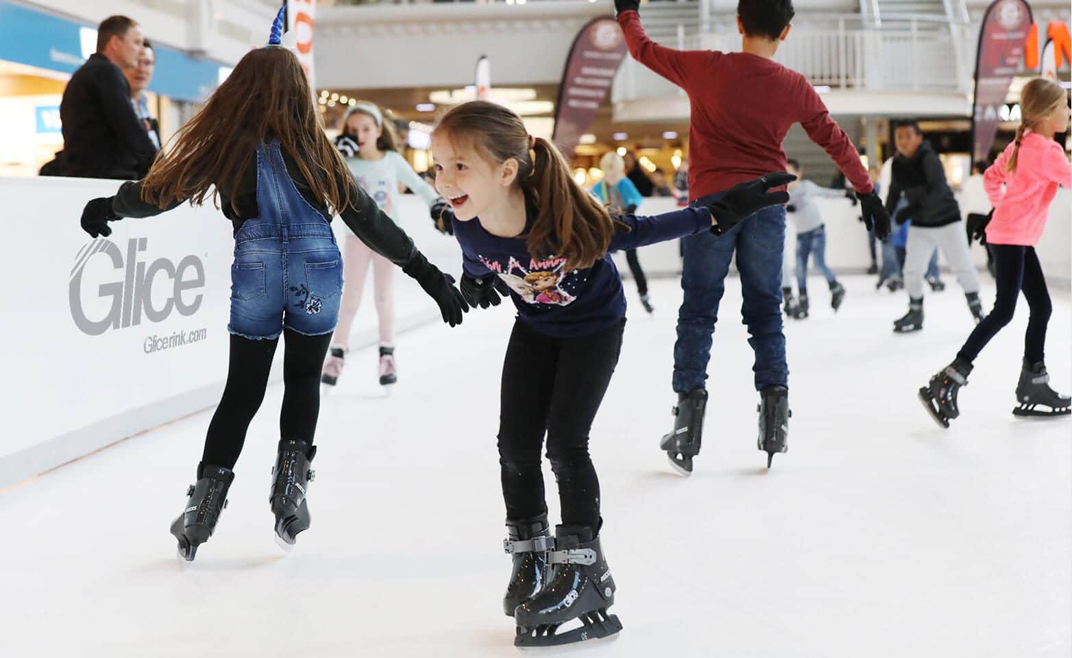 Children having fun on synthetic ice rink at Swiss mall