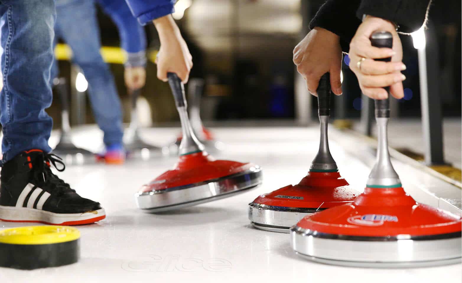 Piedras de curling en pista de hielo artificial