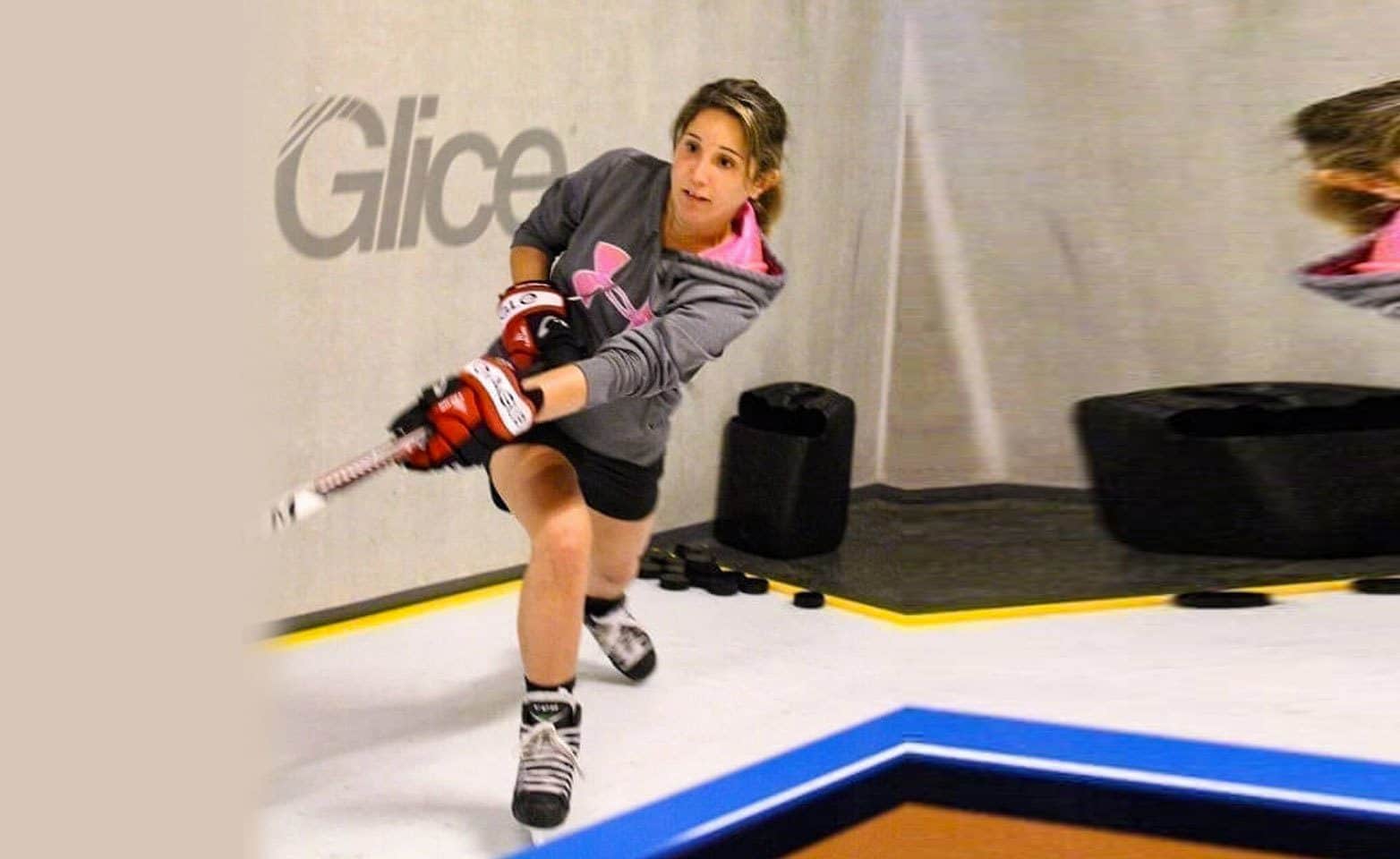 Female hockey player practicing on synthetic ice pad