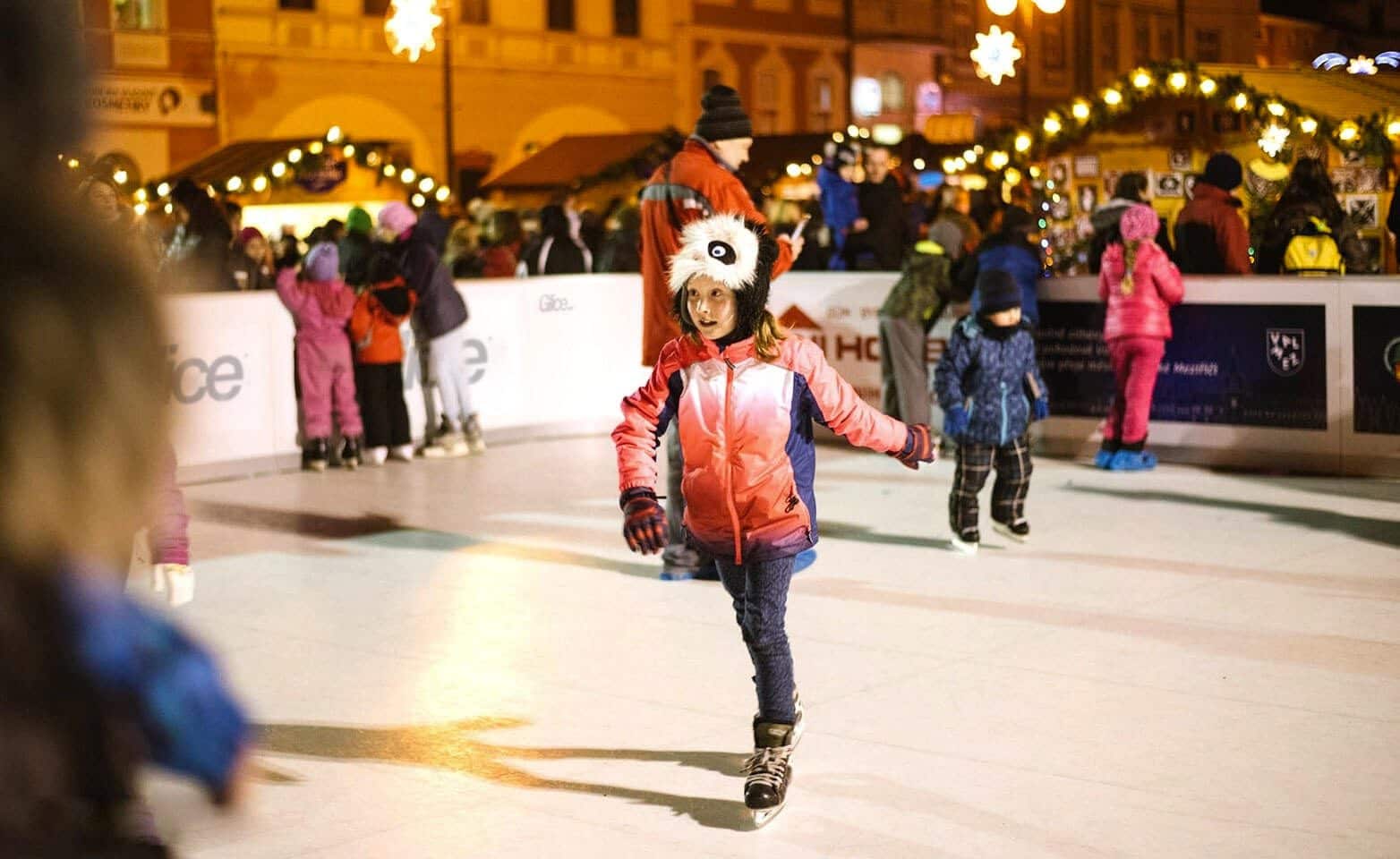 Niña patinando en una pista de hielo sintético