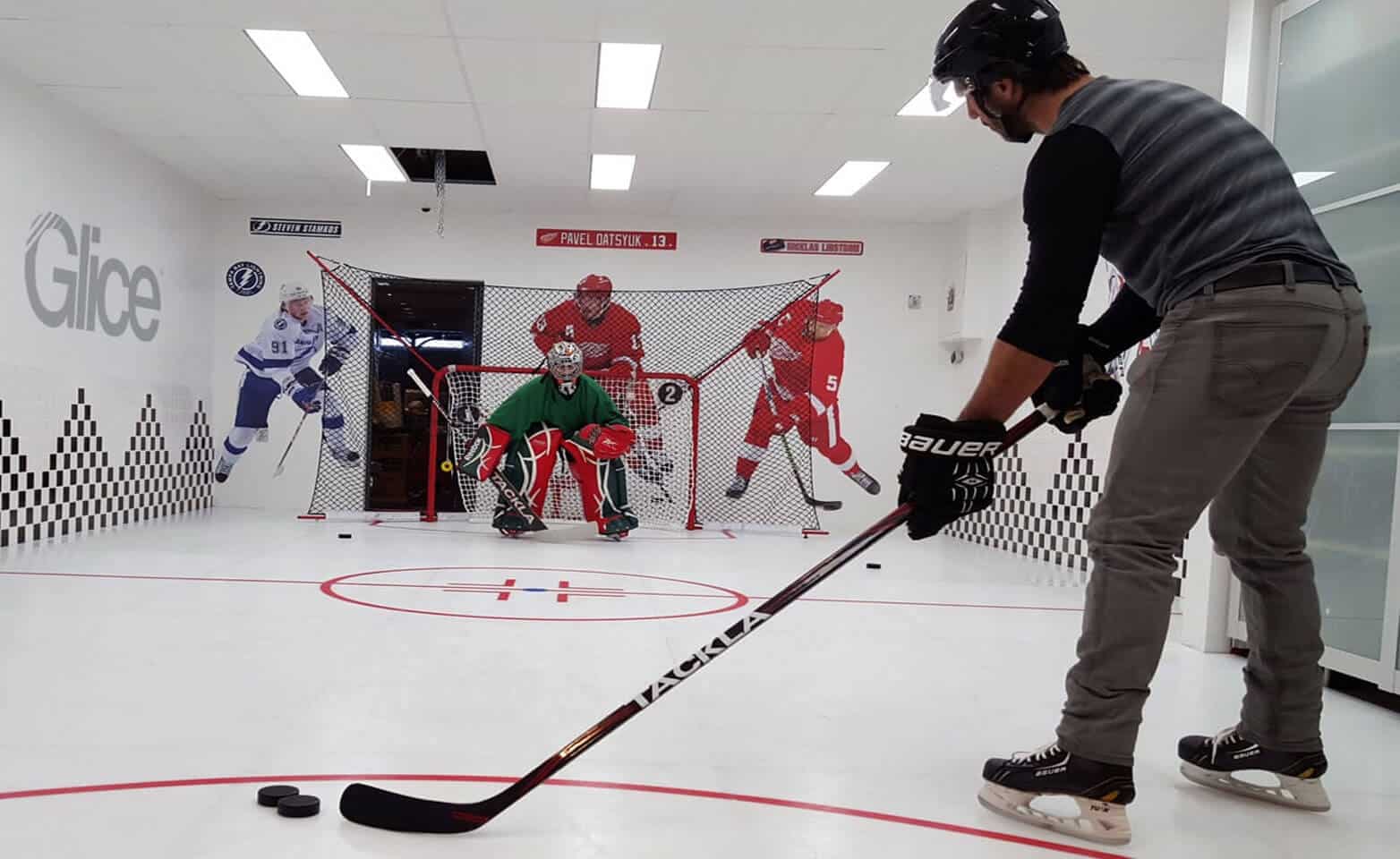 Hockey practice in synthetic ice rink with embedded hockey lines