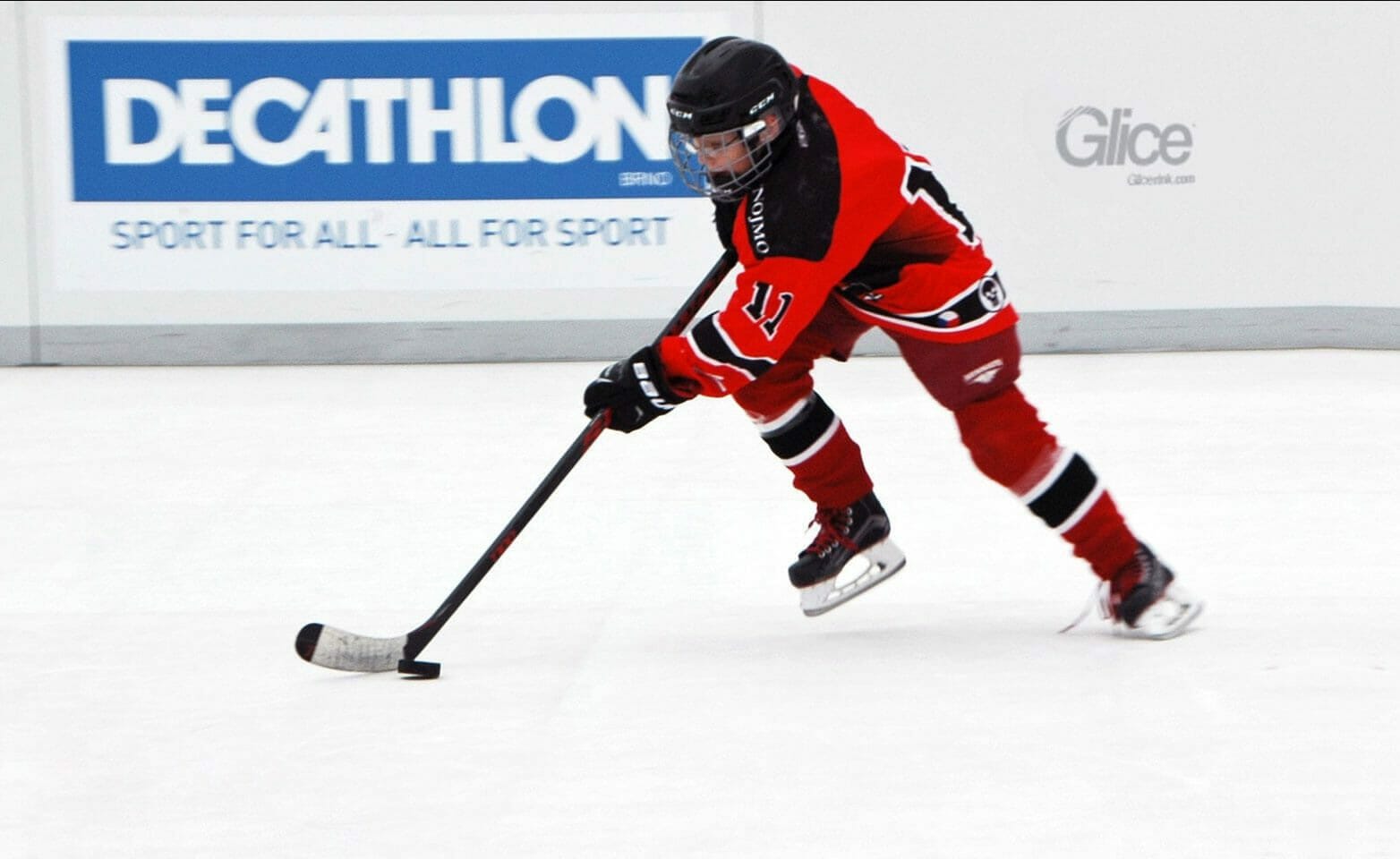 Ice hockey player gliding on artificial ice rink