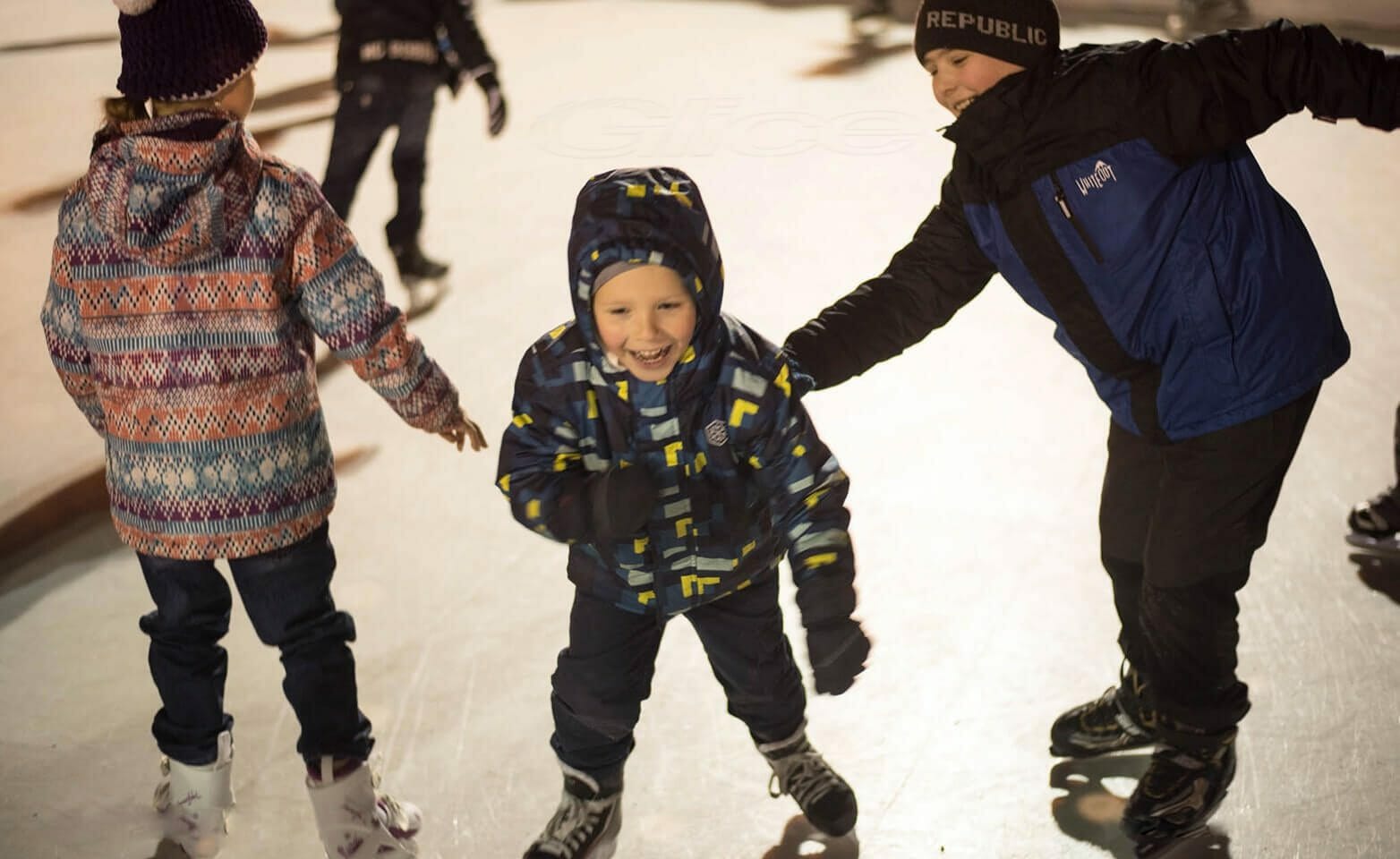 Kinder haben Spaß beim Eislaufen auf Kunsteis