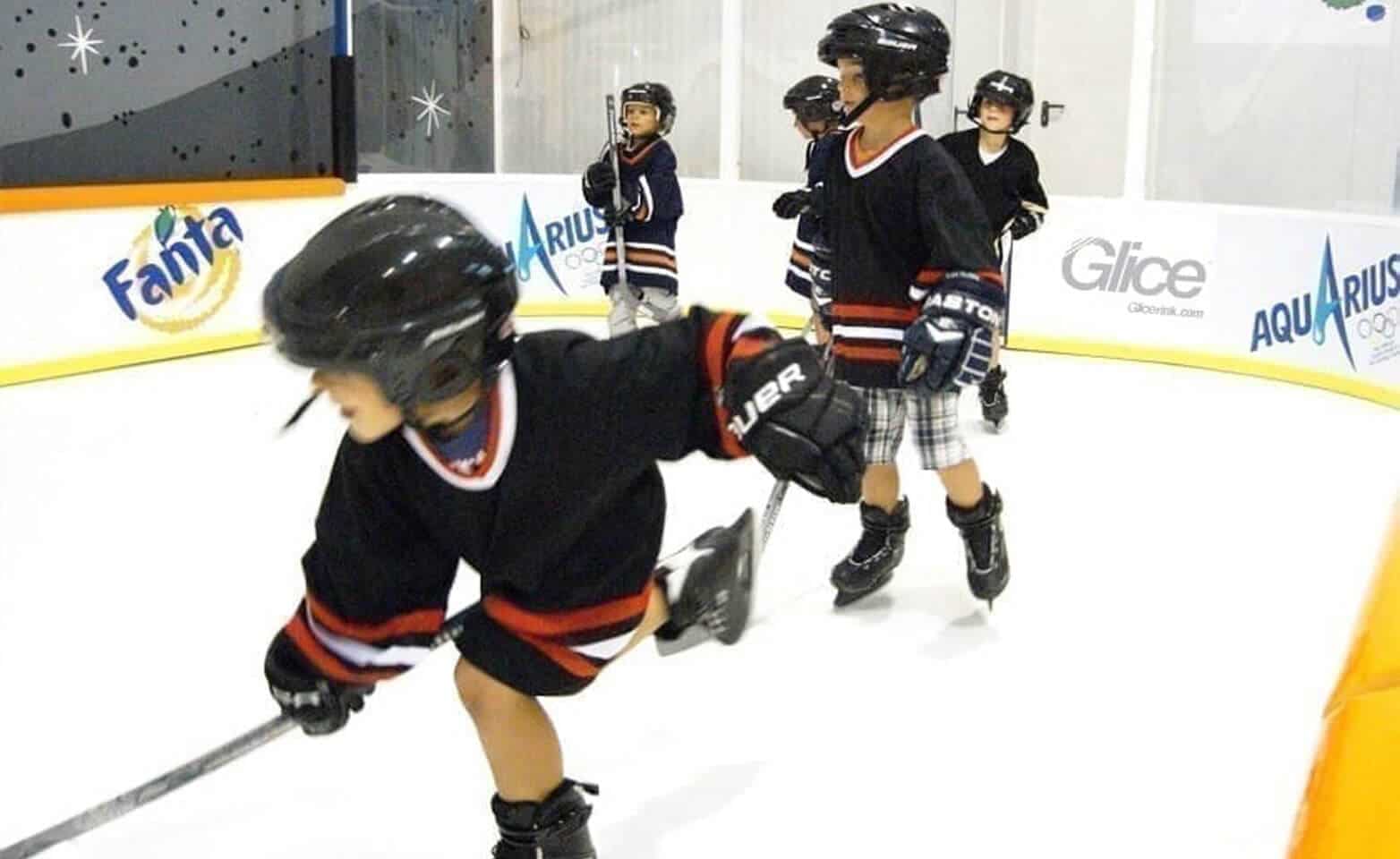 Kids playing hockey at synthetic ice rink mini arena