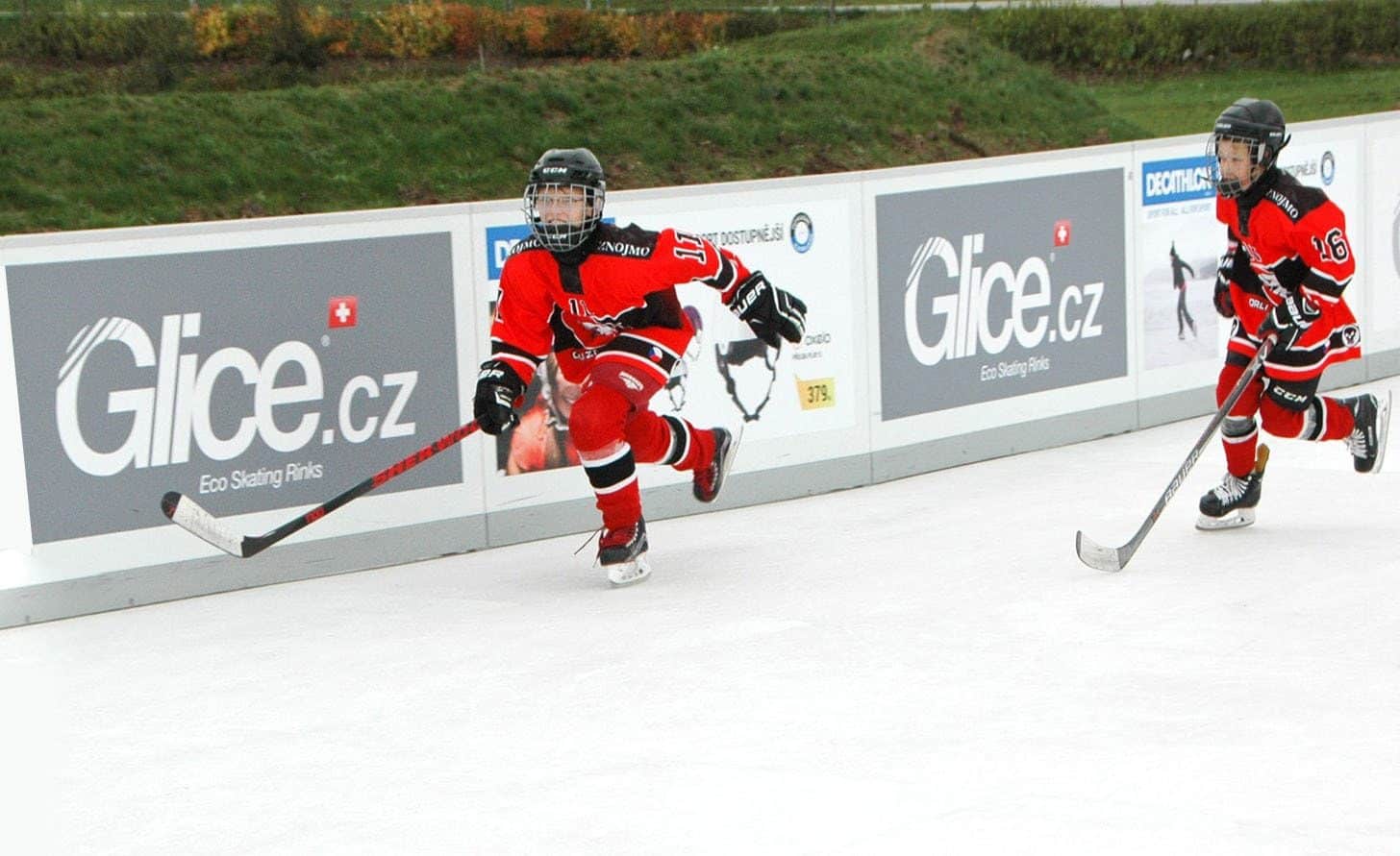 Kinder beim Hockeyspielen auf einer Glice Eisbahn