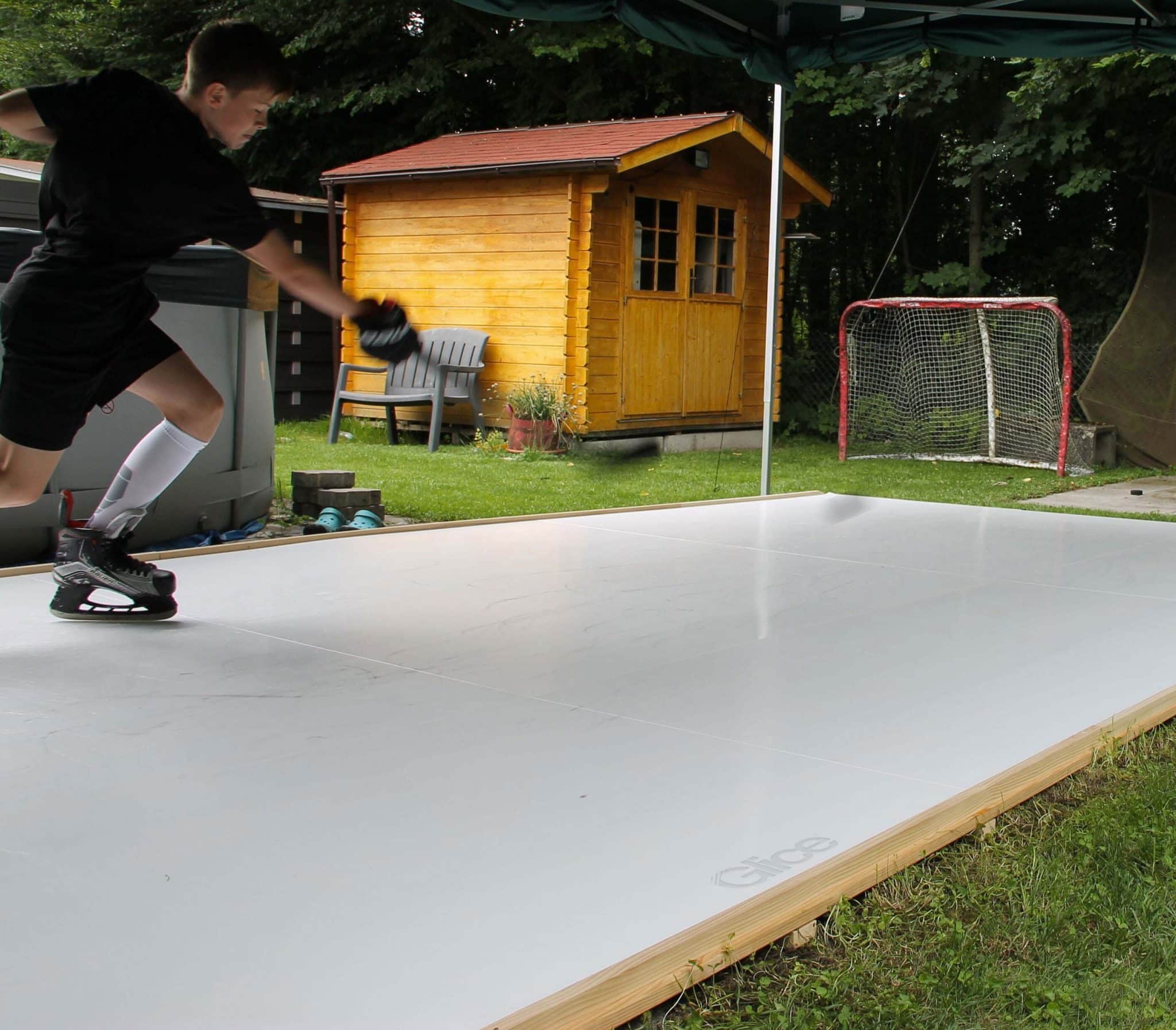 Child practicing on synthetic ice backyard pad