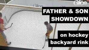 Vater und Sohn spielen Eishockey auf Kunststoffeisfeld in schweizer Garten
