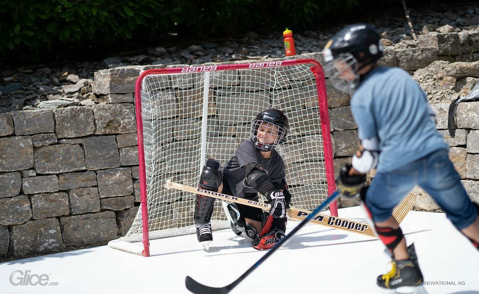 Children playing ice hockey on Glice