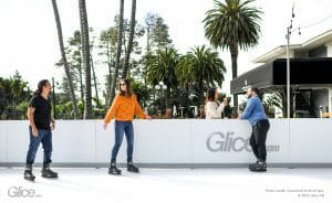 Three people ice skating in tropical setting