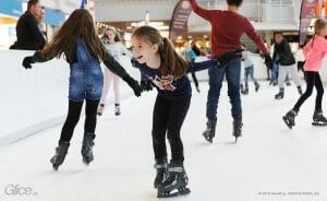 Girl happily skates on synthetic ice