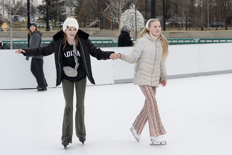 Girls ice skating hand in hand