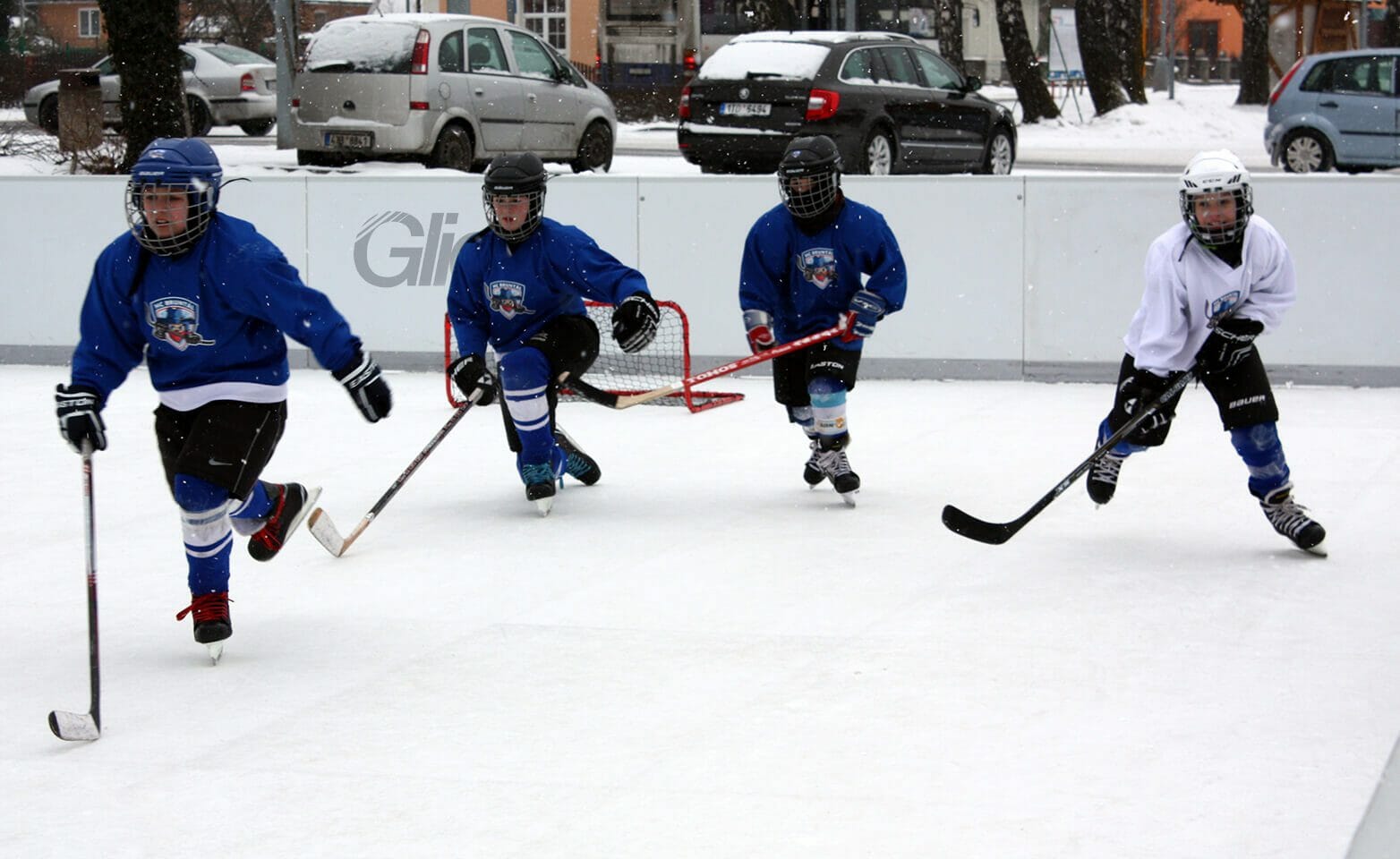 Fyra små pojkar spelar ishockey