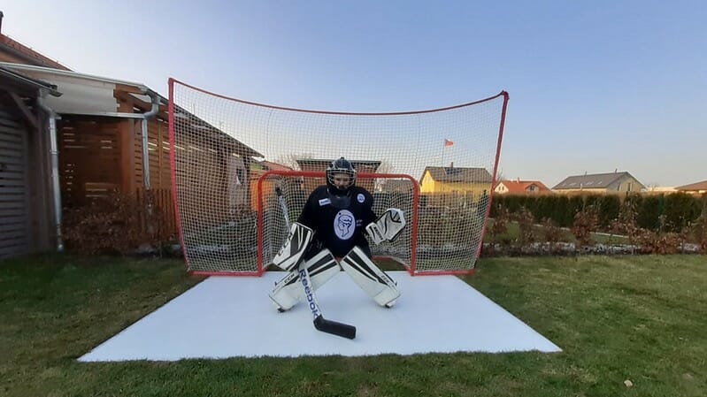 Boy playing ice hockey in his backyard