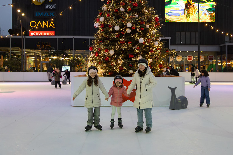 Three girls hand in hand on ice rink