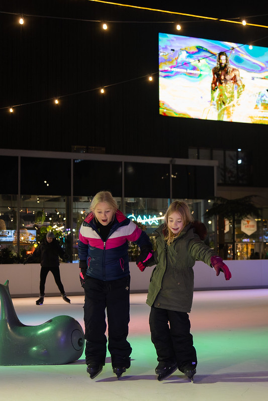 Two girls ice skating together